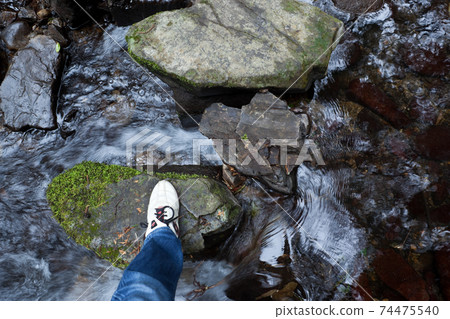 Footsteps across the stones of the mountain stream 74475540