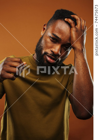 young pretty african american man posing cheerful on brown background, lifestyle people concept young pretty african american man posing cheerful on brown background, lifestyle people concept 74475673