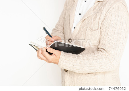 A man writing notes in a notebook 74476932
