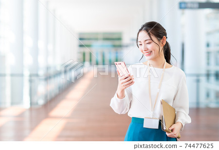 女商人,在辦公室的智能手機 女商人,在辦公室的智能手機 74477625