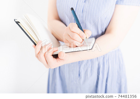 穿裙子在筆記本上寫筆記的女人 74481356