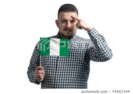 White guy holding a flag of Nigeria and a finger touches the temple on the head isolated on a white background White guy holding a flag of Nigeria and a finger touches the temple on the head isolated on a white background 74481544