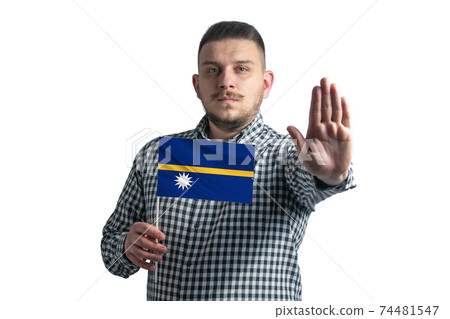 White guy holding a flag of Nauru and with a serious face shows a hand stop sign isolated on a white background 74481547