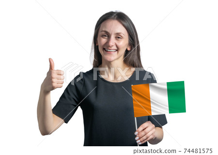 Happy young white woman holding flag of Cote d'Ivoire and shows the class by hand isolated on a white background 74481575