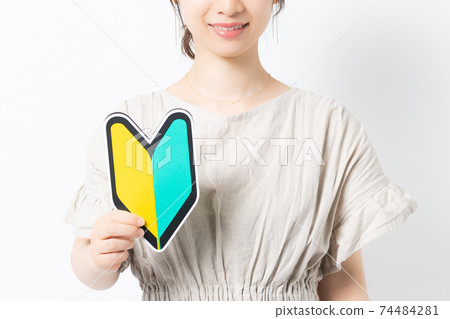 Young woman with beginner mark in front of white background 74484281