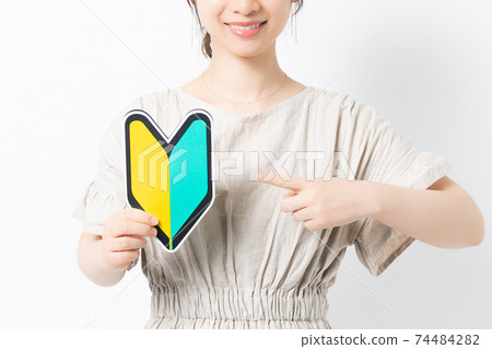 Young woman with beginner mark in front of white background 74484282