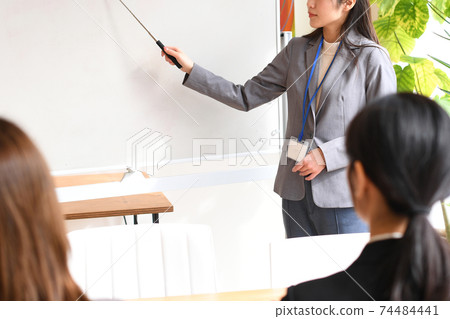 Female seminar instructor explaining on the whiteboard 74484441