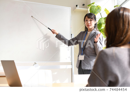 Female seminar instructor explaining on the whiteboard 74484454