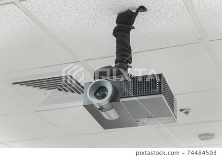A black overhead projector on ceiling indoors. 74484503