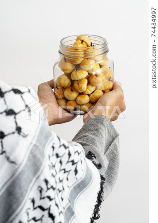 muslim hand gesture holding nastar 74484997