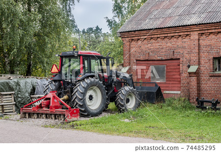 A tractor next to a farm house in the suburb of Espoo, Finland A tractor next to a farm house in the suburb of Espoo, Finland 74485295
