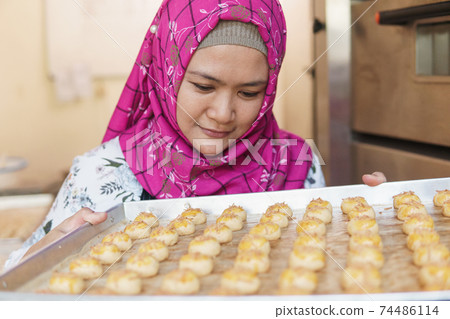 bakery owner looking at her pineapple tart 74486114