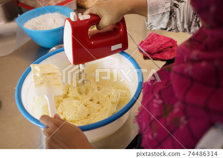 mixing dough flour to make a cake 74486314