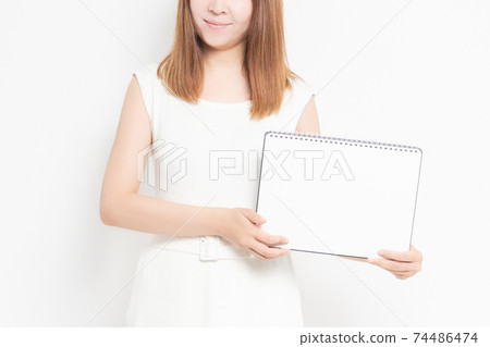 Young woman with sketchbook in front of white background Young woman with sketchbook in front of white background 74486474