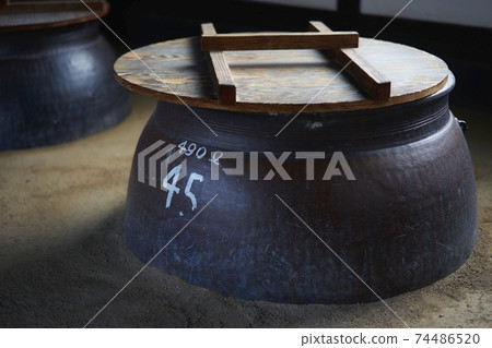 Scenery of a traditional Japanese sake brewery. I make shochu (Japanese sake) in large bottles and jars. Shochu prepared in a turtle jar. 74486520