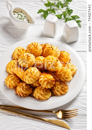 Duchess potatoes served on a white plate Duchess potatoes served on a white plate 74487441