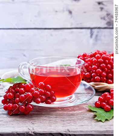 Tea from viburnum in cup on old board 74488967