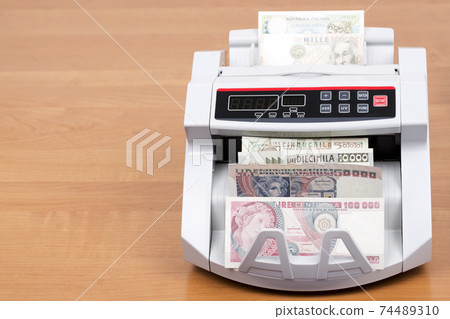 Old Italian money in the counting machine 74489310