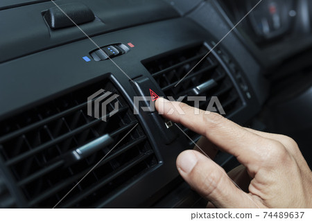 Close up hand press the emergency light in the car, Fingers press button.for open the contract emergency light in car. Emergency button press for open emergency light warning sign symbol out side car Close up hand press the emergency light in the car, Fingers press button.for open the contract emergency light in car. Emergency button press for open emergency light warning sign symbol out side car 74489637