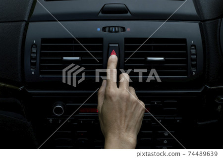 Close up hand press the emergency light in the car, Fingers press button.for open the contract emergency light in car. Emergency button press for open emergency light warning sign symbol out side car 74489639