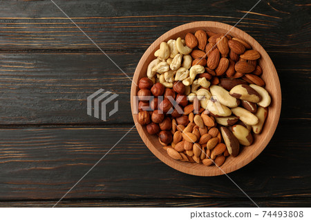 Bowl with different nuts on wooden background, top view Bowl with different nuts on wooden background, top view 74493808