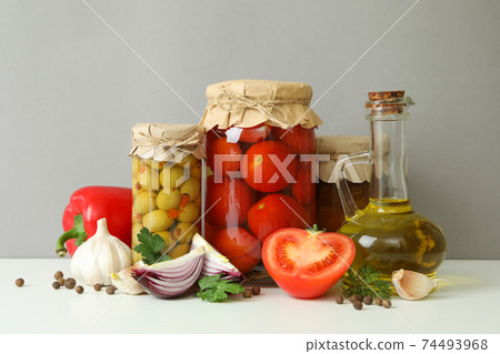 Different pickled food and ingredients against gray background 74493968