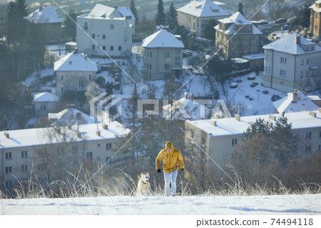 Happy young man with dog in winter 74494118