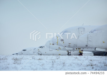 Grounded airplanes in row at airport 74494233