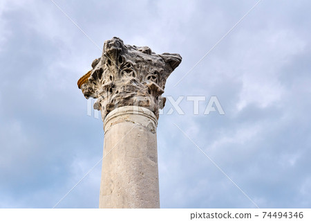 weathered capital of an antique column in the Corinthian order style against the sky weathered capital of an antique column in the Corinthian order style against the sky 74494346