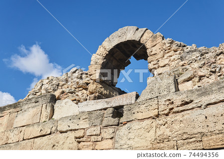 fragment of a destroyed antique fortress wall with arch against the sky fragment of a destroyed antique fortress wall with arch against the sky 74494356