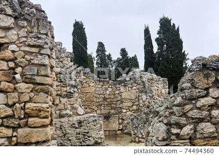 antique ruins - remains of stone walls among cypresses antique ruins - remains of stone walls among cypresses 74494360