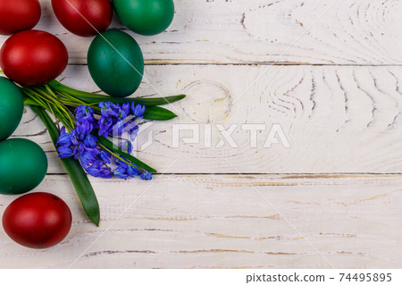 Painted Easter eggs and blue scilla flowers on white wooden background. Easter composition. Top view, copy space Painted Easter eggs and blue scilla flowers on white wooden background. Easter composition. Top view, copy space 74495895