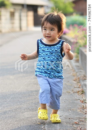 A 2-year-old boy wearing a tulip hat and taking a walk in a tank top A 2-year-old boy wearing a tulip hat and taking a walk in a tank top 74496784