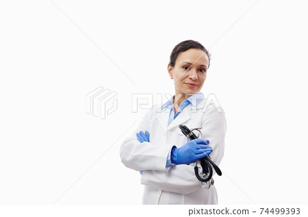 Confident portrait of a female doctor with stethoscope in hands isolated on white background with copy space. 74499393