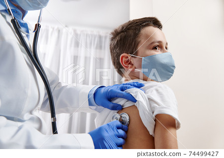 Doctor pediatrician using stethoscope, checking up heartbeat and lungs while auscultation in doctor office at hospital. 74499427