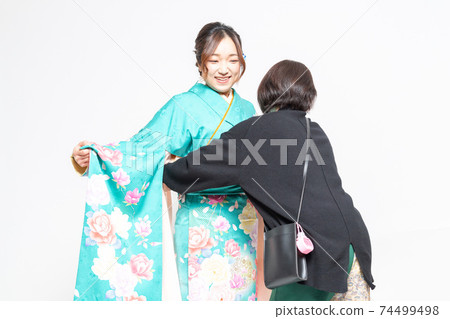 A woman who has a kimono dressed and a woman who is a dresser A woman who has a kimono dressed and a woman who is a dresser 74499498