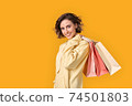 Young adult girl with shopping bags looking at camera 74501803