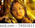 Teenager hipster girl with polyethylene film on head in vibrant neon light 74501813