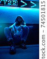 Young adult hipster woman sitting under glowing neon light 74501815