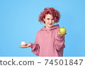 Girl in hoodie preferring fresh green apple to sweet cupcake 74501847