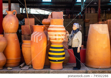 Senior woman looking at big plant pots in the small town of Raquira. The City of Pots, Colombia plant pots in the small town of Raquira. The City of Pots, Colombia Senior woman looking at big plant pots in the small town of Raquira. The City of Pots, Colombia plant pots in the small town of Raquira. The City of Pots, Colombia 74502266