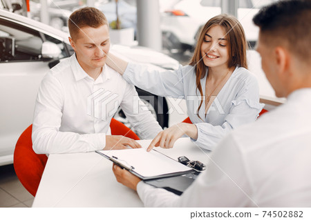 Stylish and elegant couple in a car salon 74502882