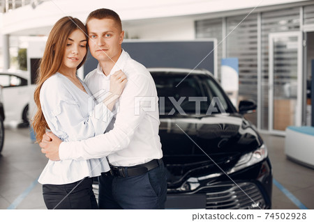 Stylish and elegant couple in a car salon 74502928