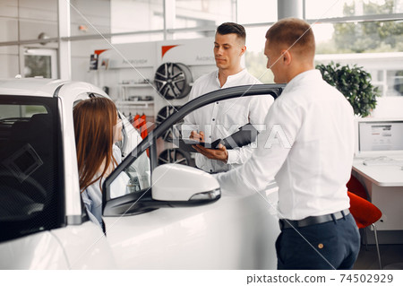 Stylish and elegant couple in a car salon Stylish and elegant couple in a car salon 74502929