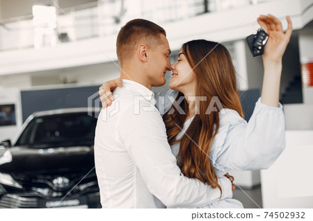 Stylish and elegant couple in a car salon Stylish and elegant couple in a car salon 74502932