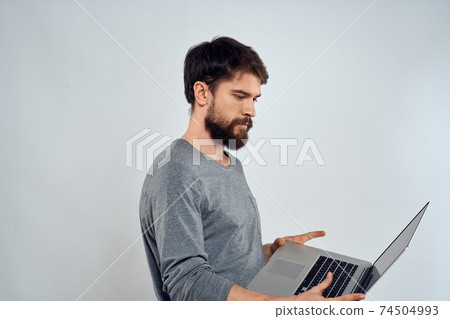 Emotional man holding a laptop success modern style work light background 74504993