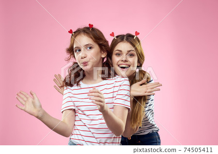 Cheerful mom and daughter joy lifestyle studio pink background family 74505411