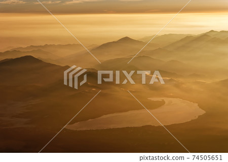 Mountain range of morning haze and Lake Yamanaka seen from the summit of Mt. Fuji Mountain range of morning haze and Lake Yamanaka seen from the summit of Mt. Fuji 74505651
