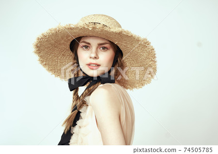 cute girl in straw hat with black ribbon and dress on light background cropped view 74505785