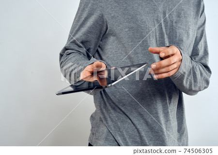 Man with tablet in hands technology lifestyle internet communication work light background cropped view Man with tablet in hands technology lifestyle internet communication work light background cropped view 74506305